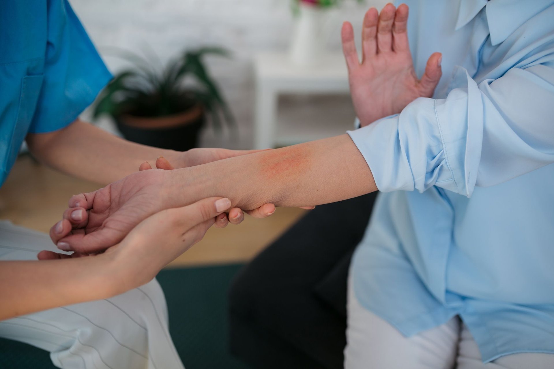 Arzt inspiziert eine gereizte Stelle mit Kontaktallergie an dem Arm einer Patientin
