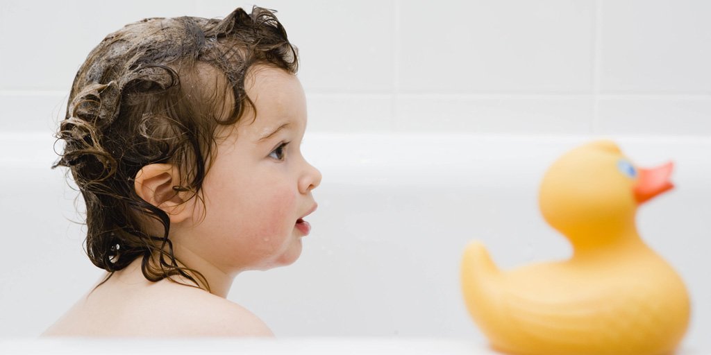 Kleinkind mit eingeschäumtes Haaren in der Badewanne