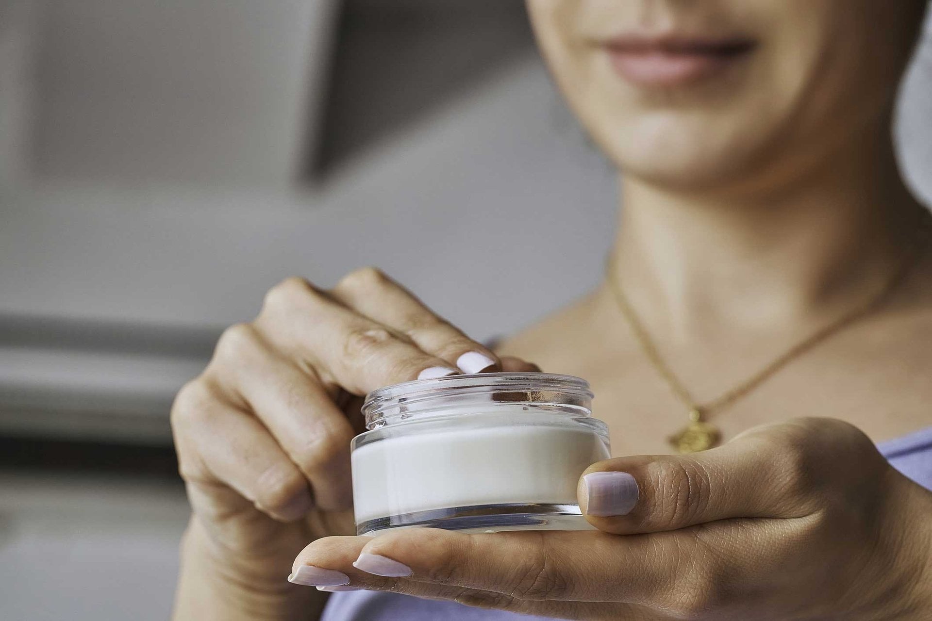 Nahaufnahme Frau hält einen Tiegel mit Creme