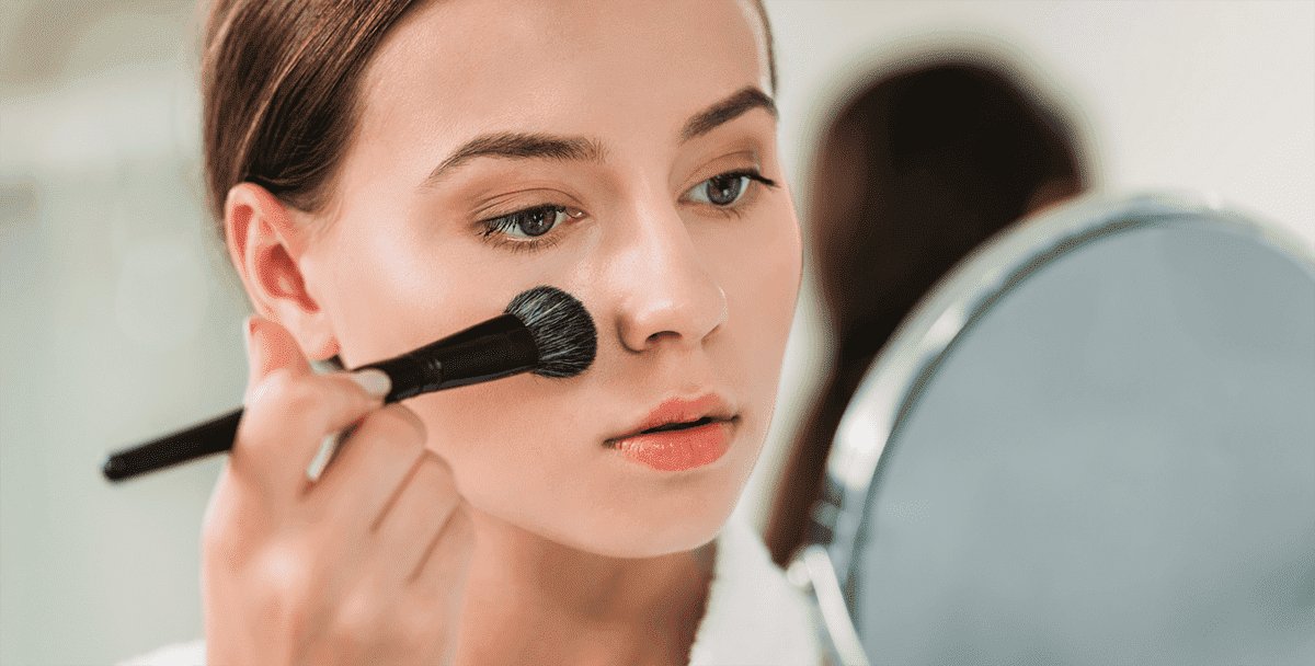 Frau mit Pinsel: Make-up bei empfindlicher Haut