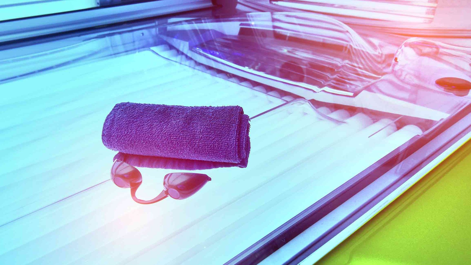 Augenschutzbrille und ein zusammengerolltes Handtuch auf einem Solarium