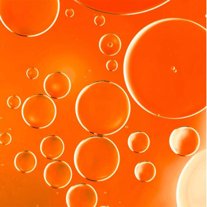 Abstrakte Darstellung durchscheinender orangefarbener Blasen, die die Molekülstruktur des Inhaltsstoffes Polymer veranschaulichen.